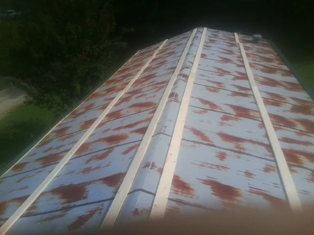 Rusted metal roof panels with new wood purlins before replacement — Storm Damage Roof Repair in Lyles by Roofing Brothers