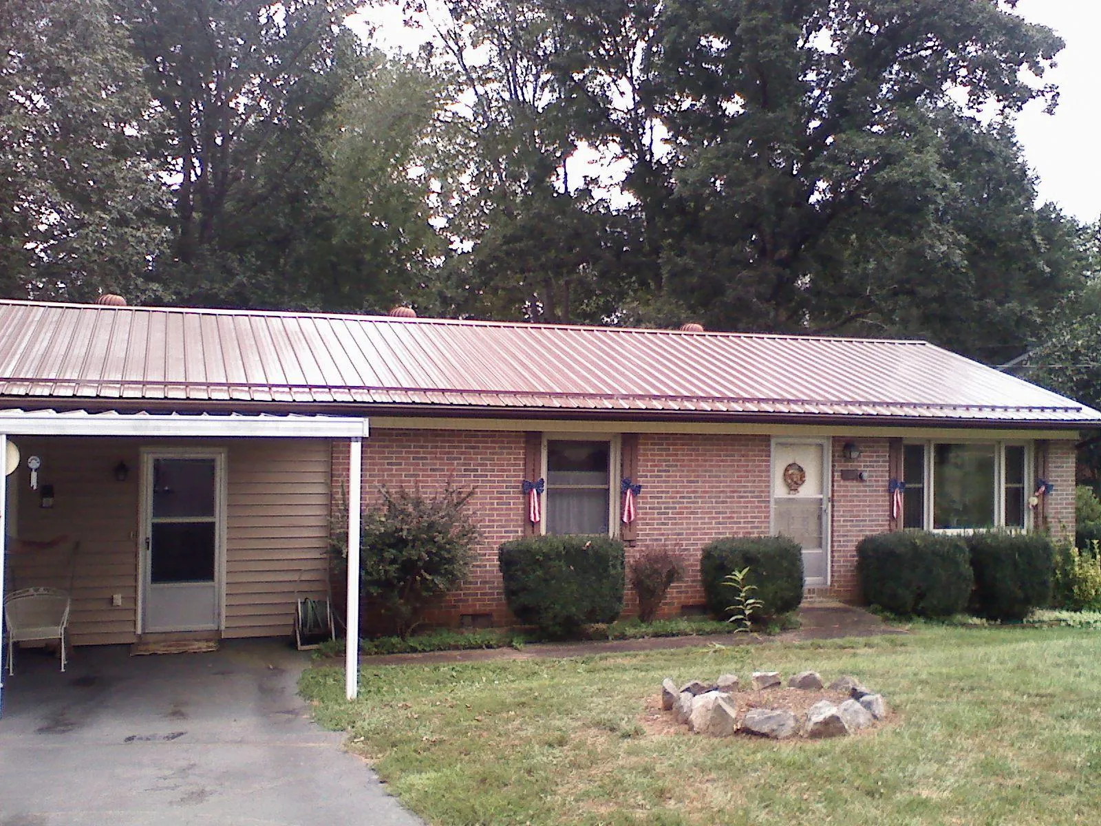 Bronze metal roof and carport on a brick ranch home — Roof Repair work by our crew in Lyles