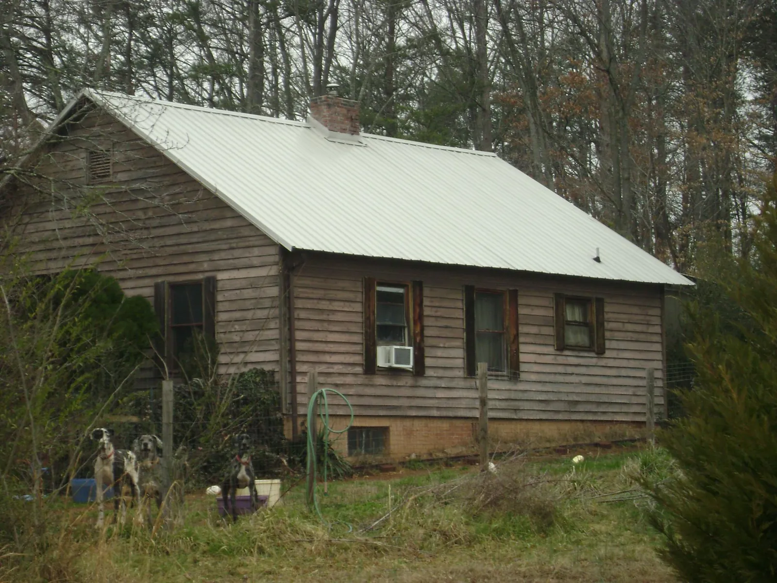 White metal roof on an old wood sided farmhouse, from a Metal Roof Installation job in Lyles